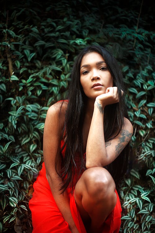 Woman in Red Dress with Her Hand on Her Chin