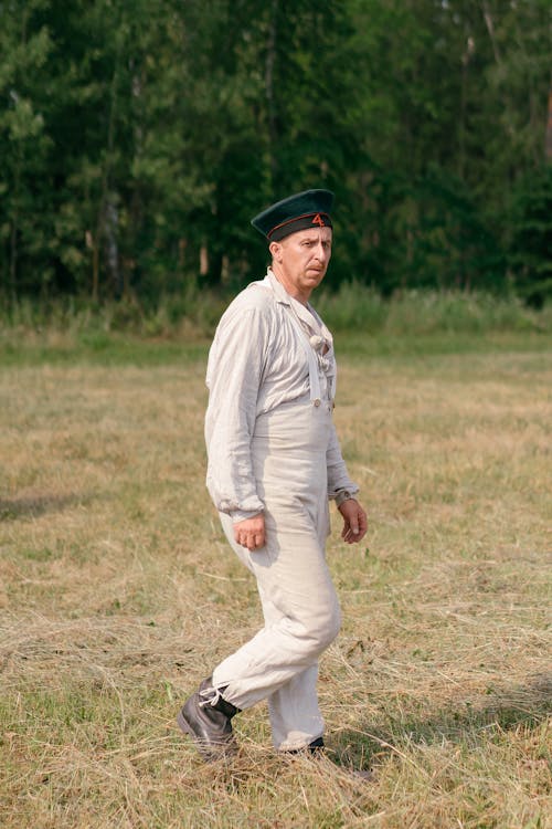Soldier in a Historical Uniform Walking on the Grass Field 
