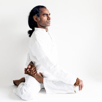 Indian yogi demonstrates an advanced yoga pose in serene white attire, embodying calm and meditation.