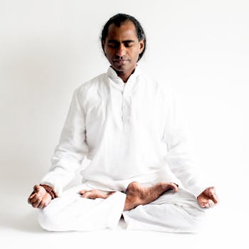 Indian yogi practicing meditation in white attire, embodying calm and mindfulness.