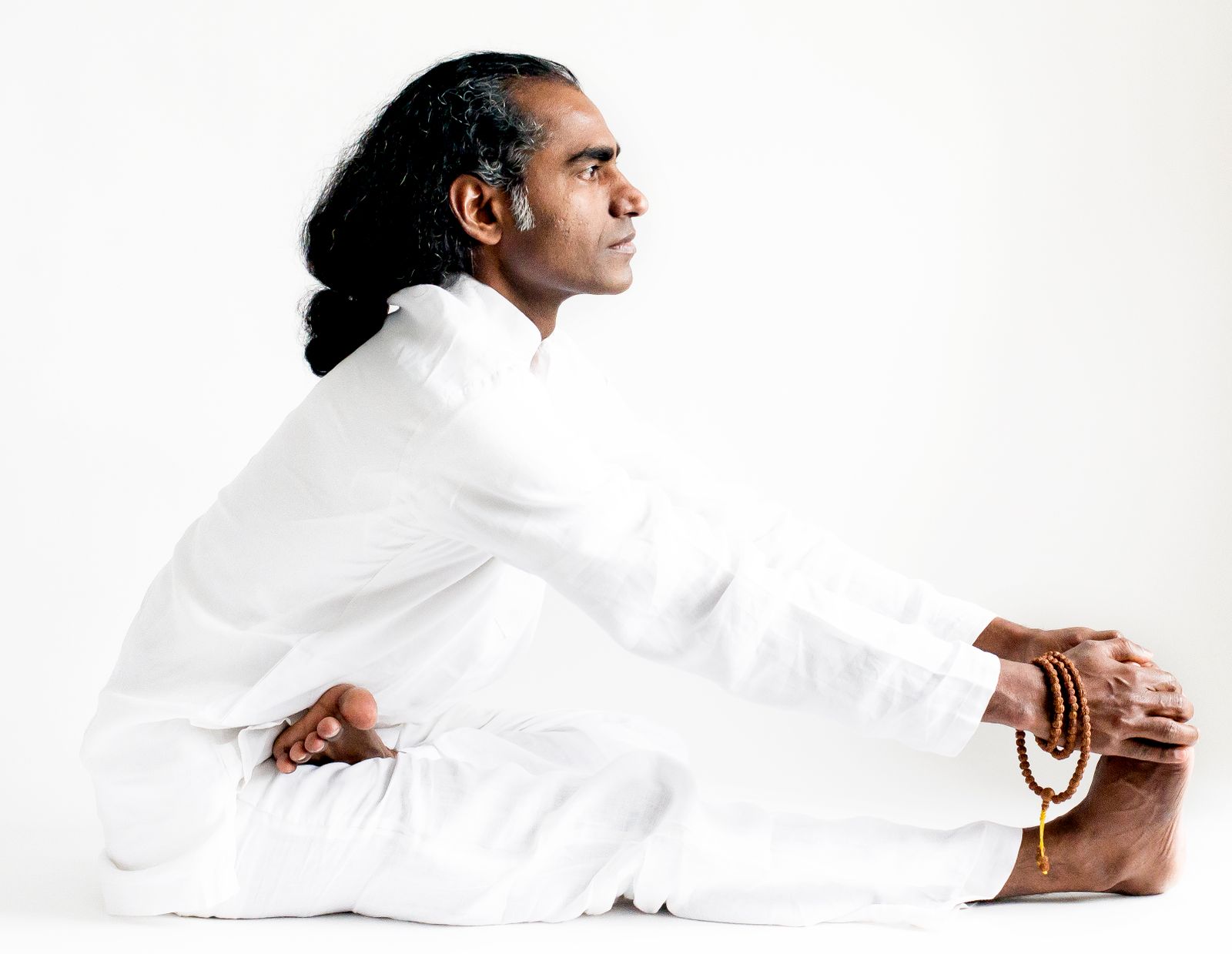 Yogi practicing seated forward bend paschimottanasana pose demonstrating proper alignment