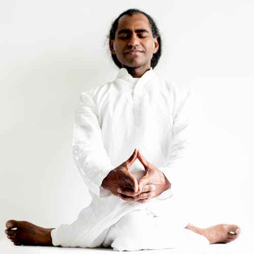 Man in White Dress Shirt Sitting on White Floor