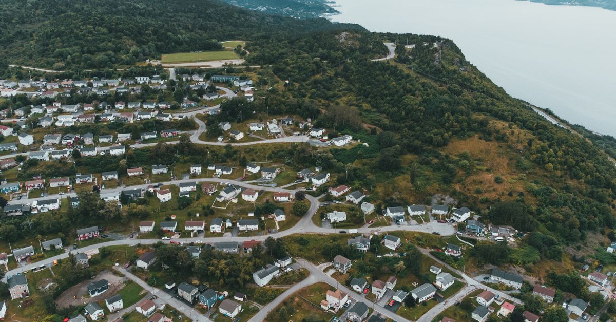 Aerial view of a suburban residential area with winding roads by the coastline.