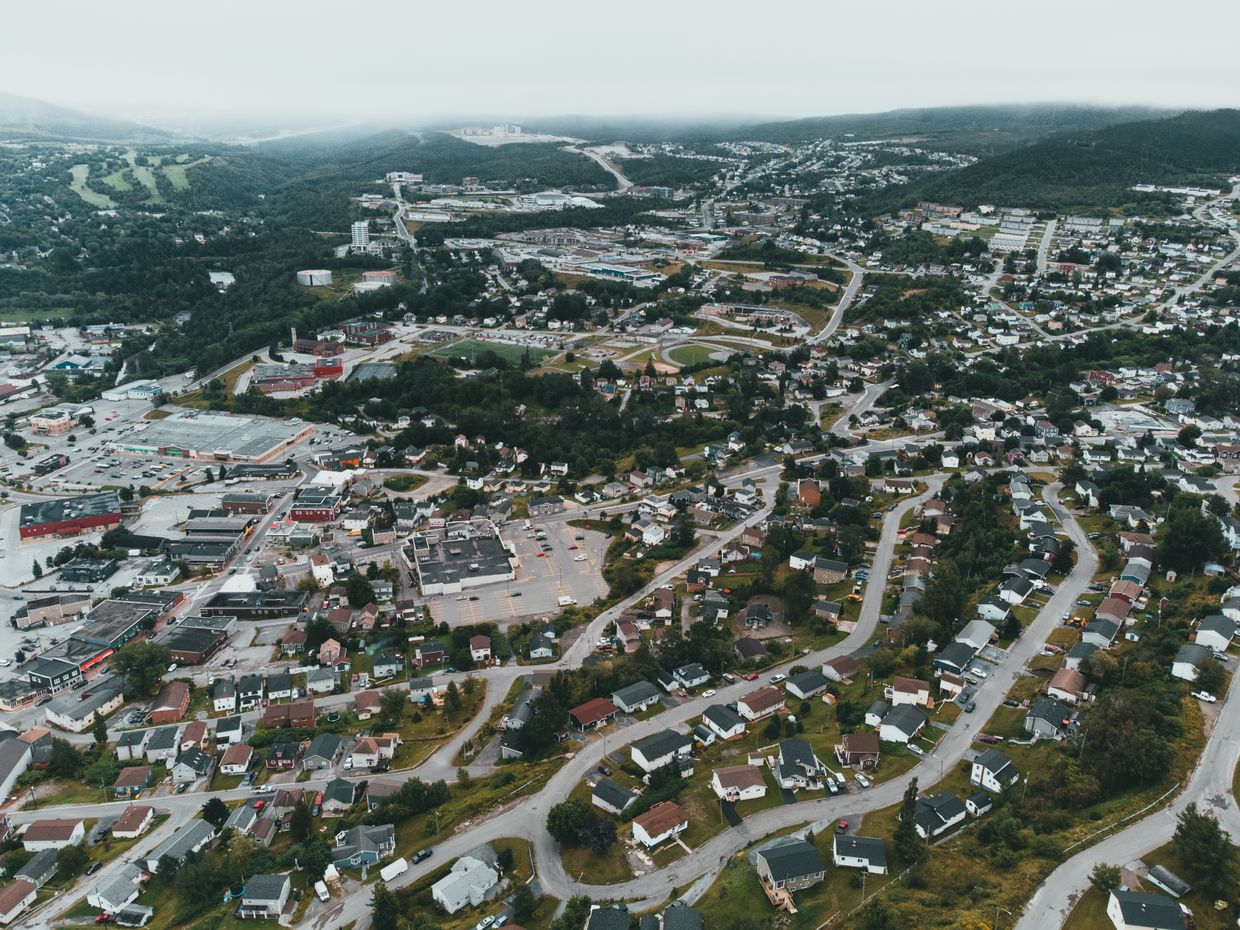 Aerial perspective of a sprawling suburban area surrounded by green setting