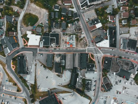 Overhead view of a busy urban intersection surrounded by buildings and parking lots.