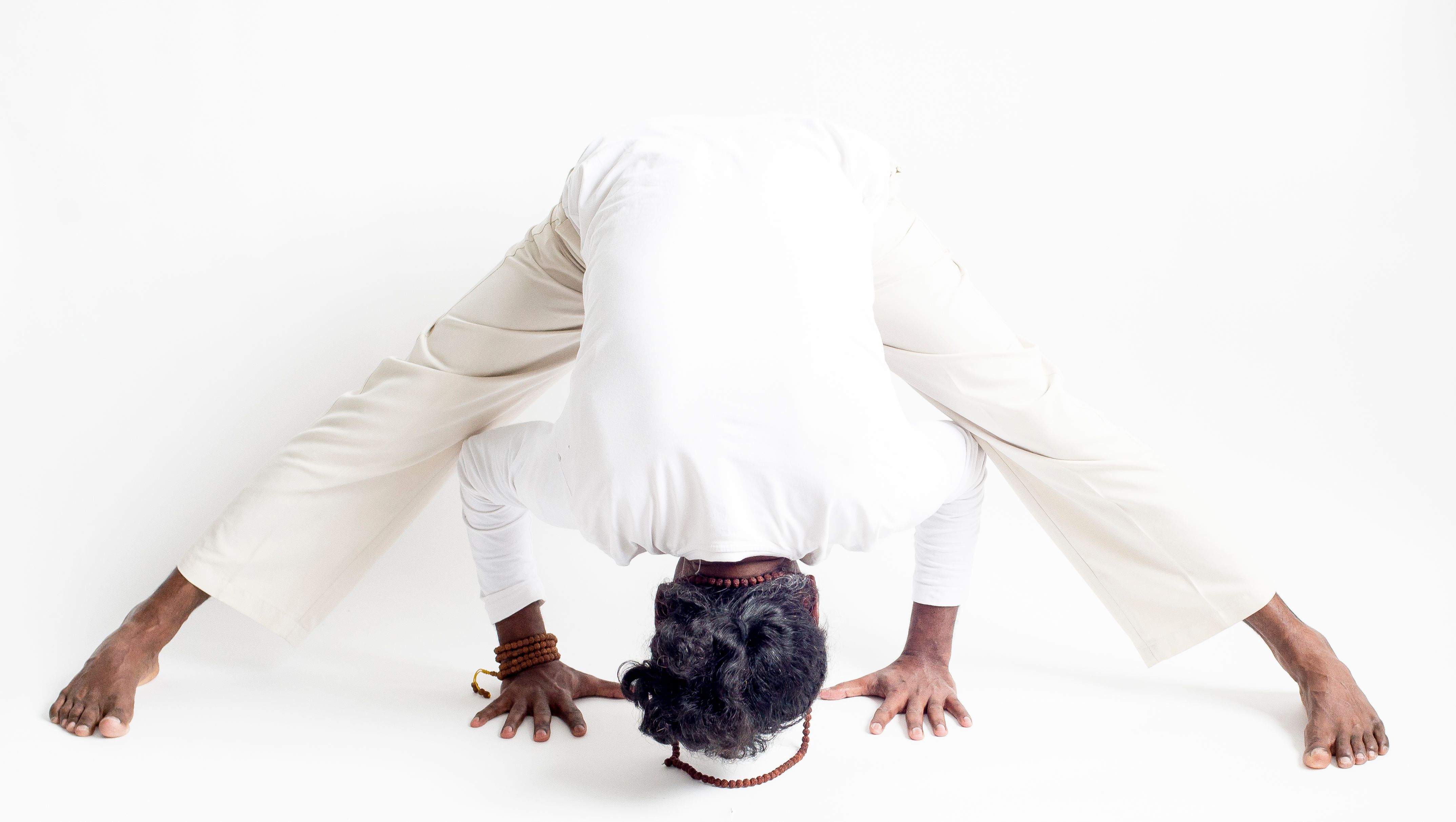 A man practicing yoga in a forward bend pose, promoting flexibility and focus.