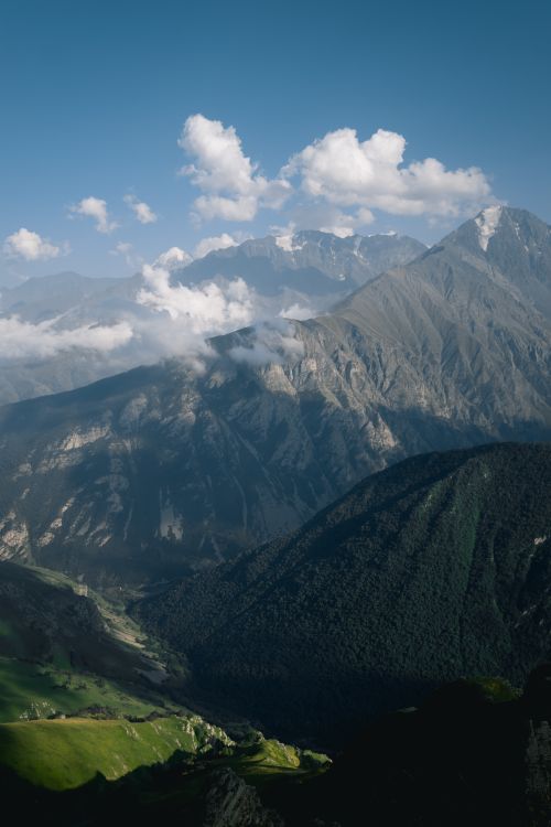 Free Breathtaking view of towering mountains under a clear sky with clouds, perfect for nature lovers. Stock Photo