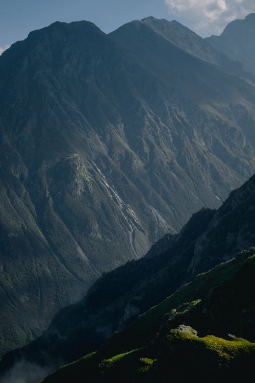 Free A breathtaking view of towering mountains enveloped in mist, showcasing nature's grandeur. Stock Photo