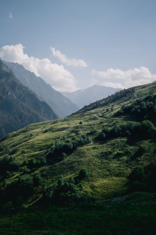 Free Breathtaking view of a lush green mountain range under a clear blue sky, perfect for nature and travel themes. Stock Photo