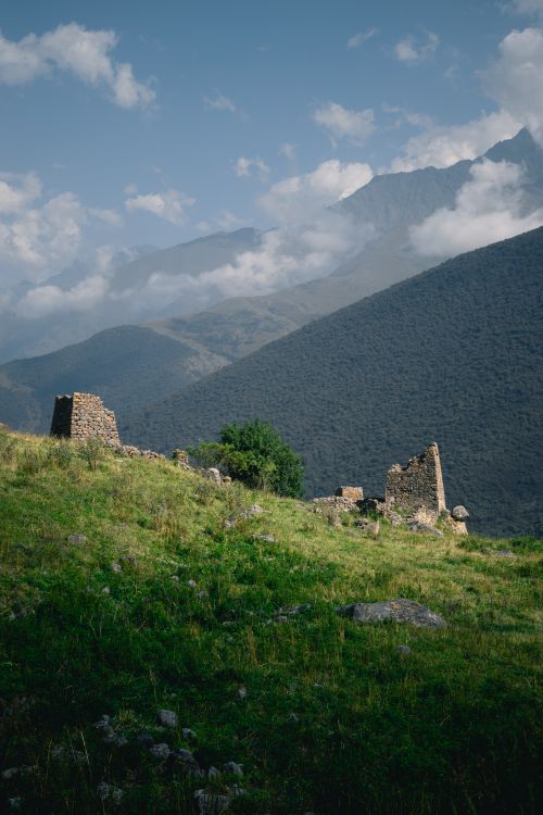 Free Explore the serene beauty of ancient ruins nestled in lush mountain landscapes under clear blue skies. Stock Photo