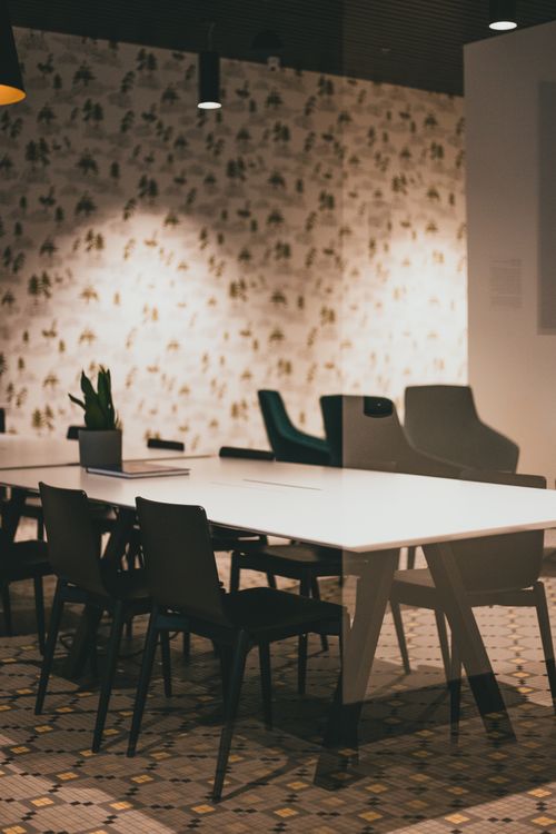 Free Stylish conference room interior featuring black chairs, tables, and decorative wallpaper, perfect for meetings. Stock Photo