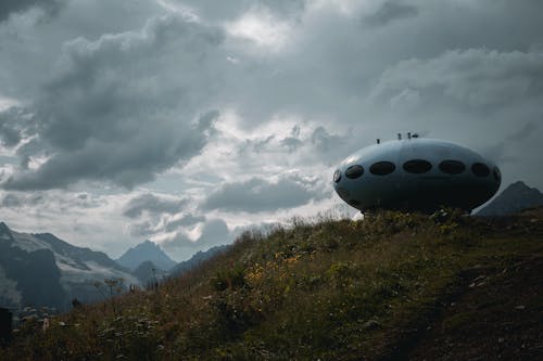 Fabricated Spaceship on Grass Field Under Gray Clouds