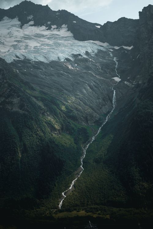 Free Discover a stunning aerial view of a mountain range with a flowing river, showcasing nature's beauty. Stock Photo