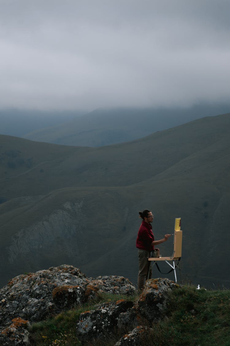 Man Painting On Canvas On Top Of A Mountain 