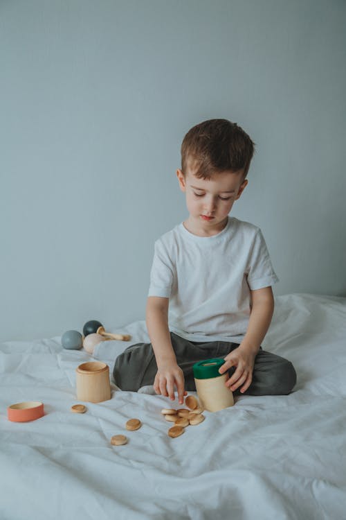 Photo of a Boy Playing with Wooden Toys