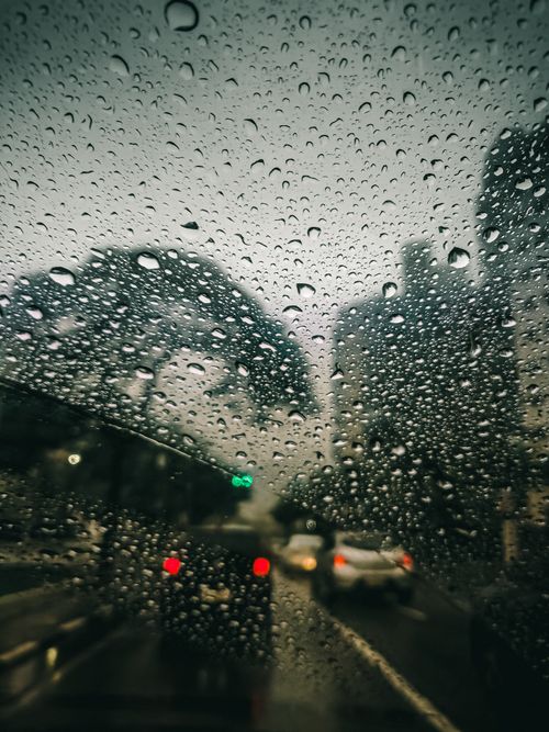 Free Blurred São Paulo cityscape through a car window covered in raindrops, capturing urban life in the rain. Stock Photo