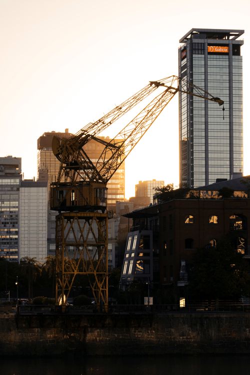 Free City skyline with industrial crane silhouetted against sunset, showcasing urban development. Stock Photo