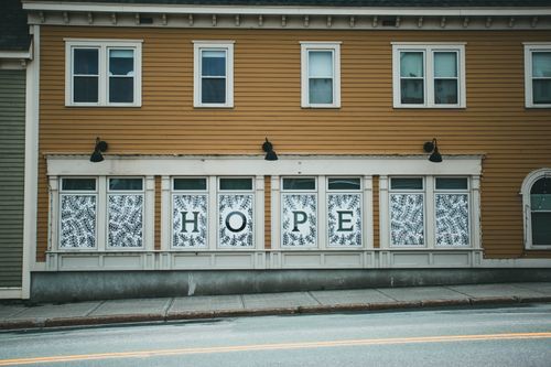 Free Exterior view of urban building with 'HOPE' sign on windows, creating an inspiring atmosphere. Stock Photo