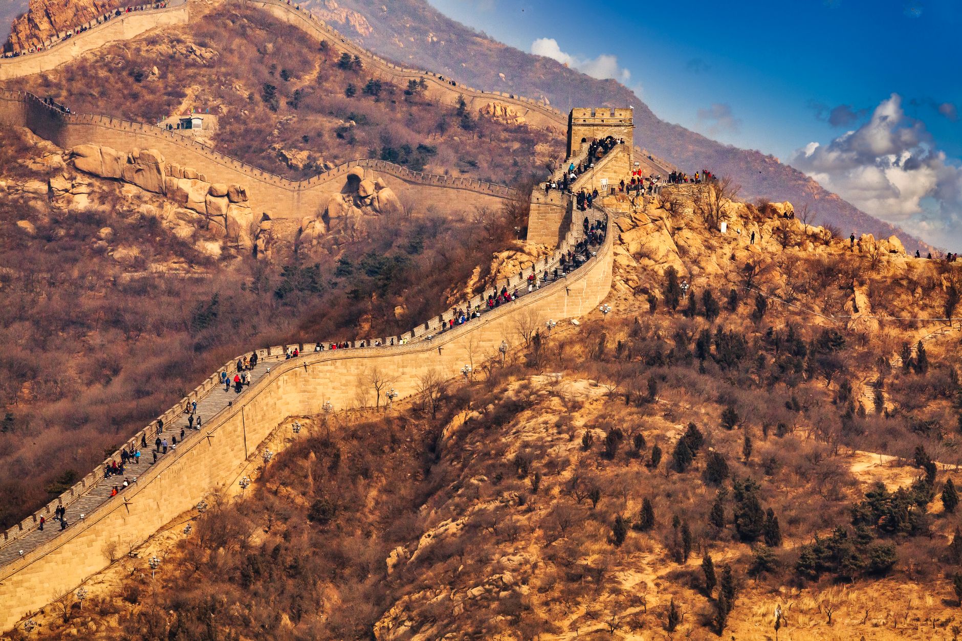 The majestic Great Wall of China stretches across picturesque mountains, drawing in global tourists.