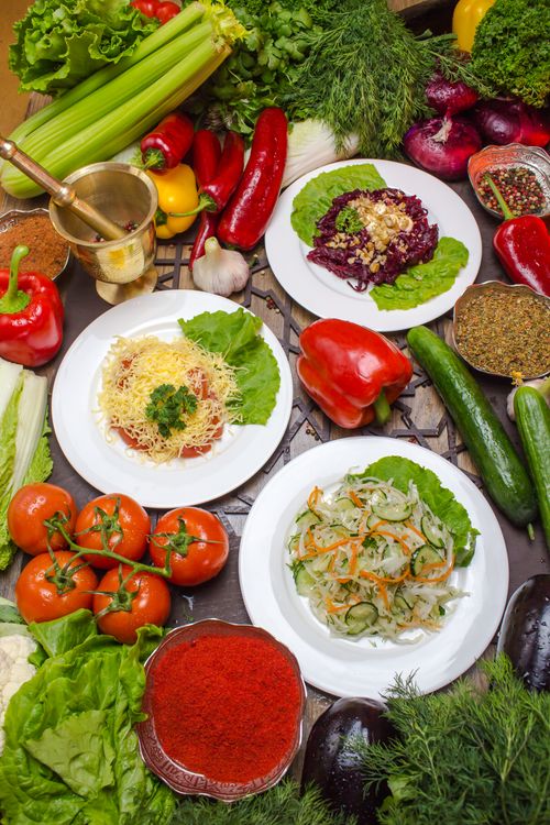 Free Colorful vegetable salad and pasta dishes surrounded by fresh herbs and spices. Perfect for healthy eating. Stock Photo