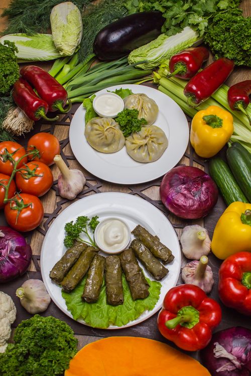 Free A colorful arrangement of fresh vegetables and traditional dishes on plates, offering a healthy and organic feel. Stock Photo