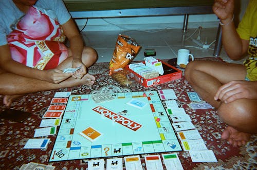 Free Two People Playing Monopoly Board Game  Stock Photo