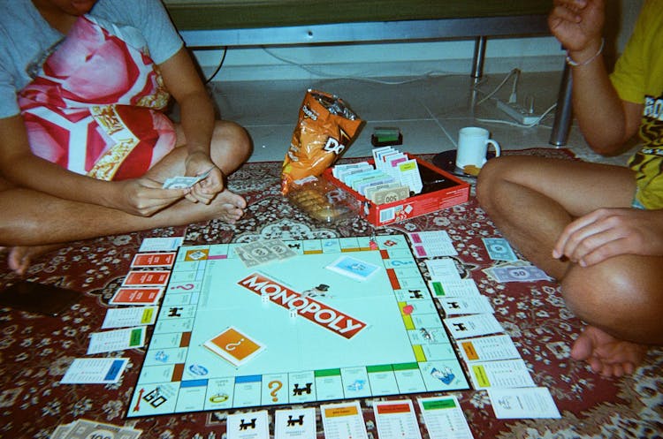 Two People Playing Monopoly Board Game 