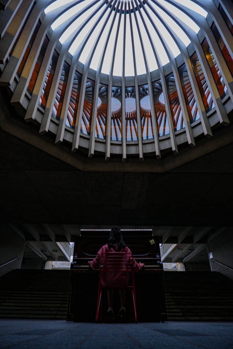 Back View Of A Person Playing The Piano At The SFU Transportation Centre, Simon Fraser University In Burnaby, British Columbia, Canada