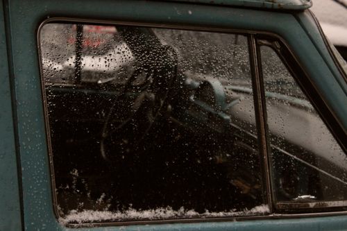 Free Close-up of a vintage car window with raindrops and snow. Winter season atmosphere. Stock Photo