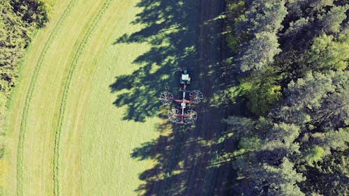 Aerial View of a Harvester on a Grassy Field