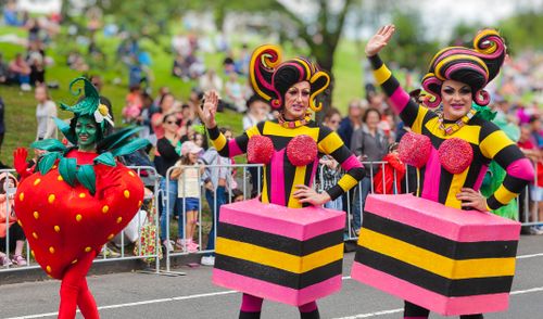 Free Bright costumes and lively participants in a festive outdoor parade. Stock Photo