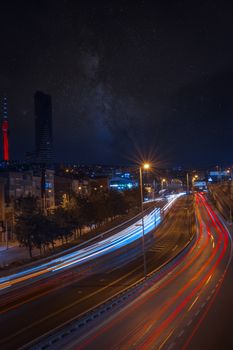 Long exposure captures vibrant light trails on a bustling Istanbul road at night.