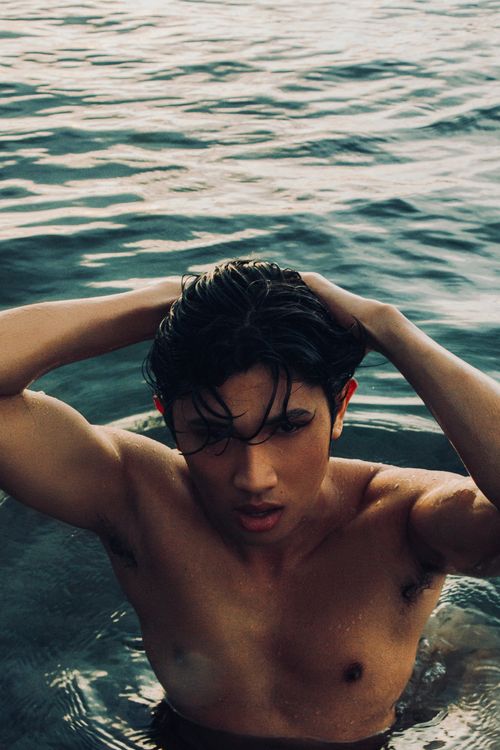 Free Shirtless young man in water, wet hair, looking intense. Stock Photo