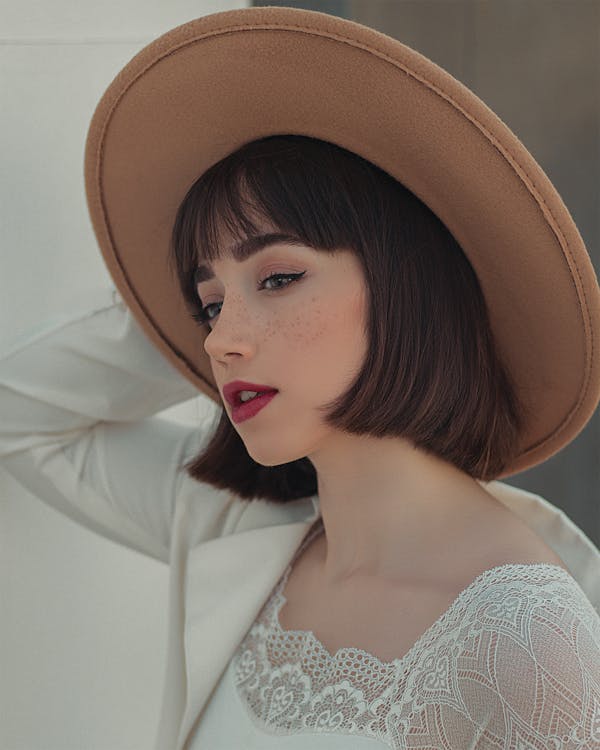 Close-Up Shot of a Pretty Woman in White Top Wearing Brown Sun Hat