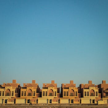A picturesque row of terraced houses set against a bright clear blue sky, showcasing modern architecture.