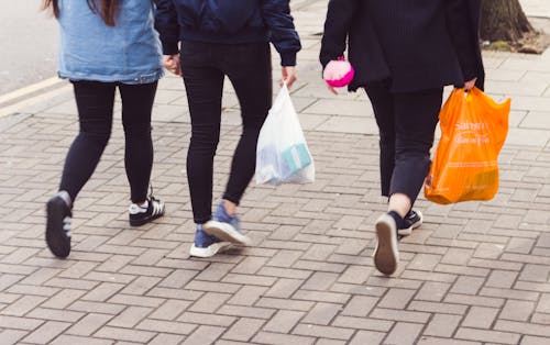 Foto d'estoc gratuïta de 3 persones caminant, adolescents, bosses de la compra