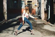 阳光明媚的城市街道上，时尚的女人自信地走着