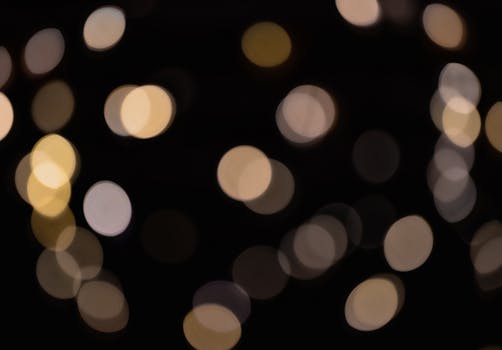 Close-up of colorful bokeh light circles with a black backdrop, creating a dreamy and abstract atmosphere.