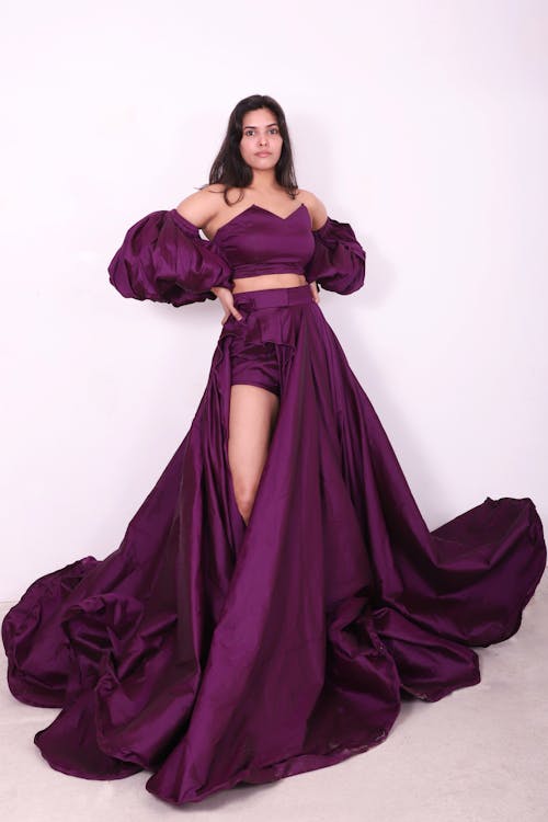 Free Fashion model posing in a stunning purple dress, showcasing high fashion elegance. Stock Photo