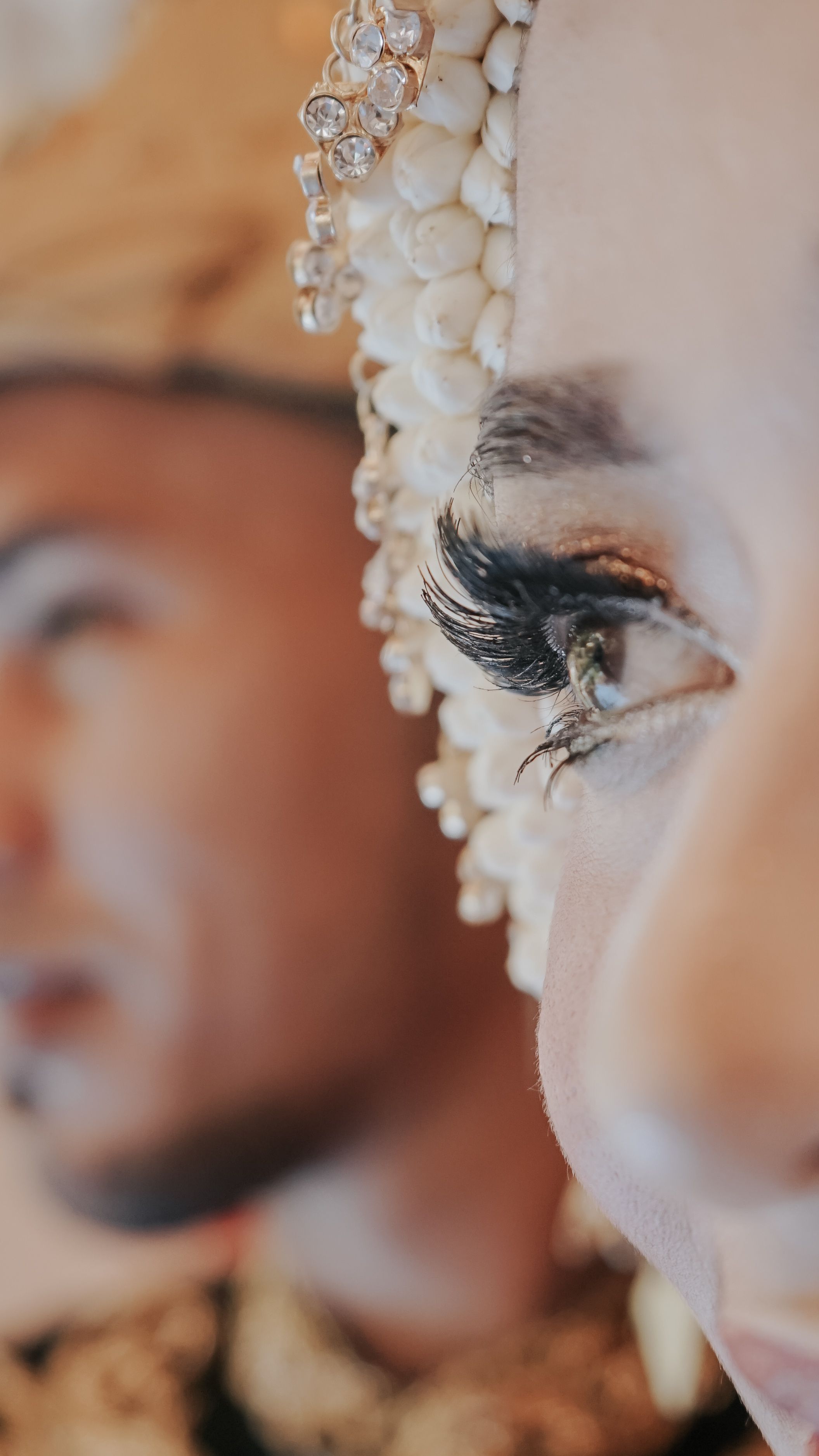 Elegant close-up of a woman's eye with traditional bridal makeup and attire, highlighting cultural beauty.