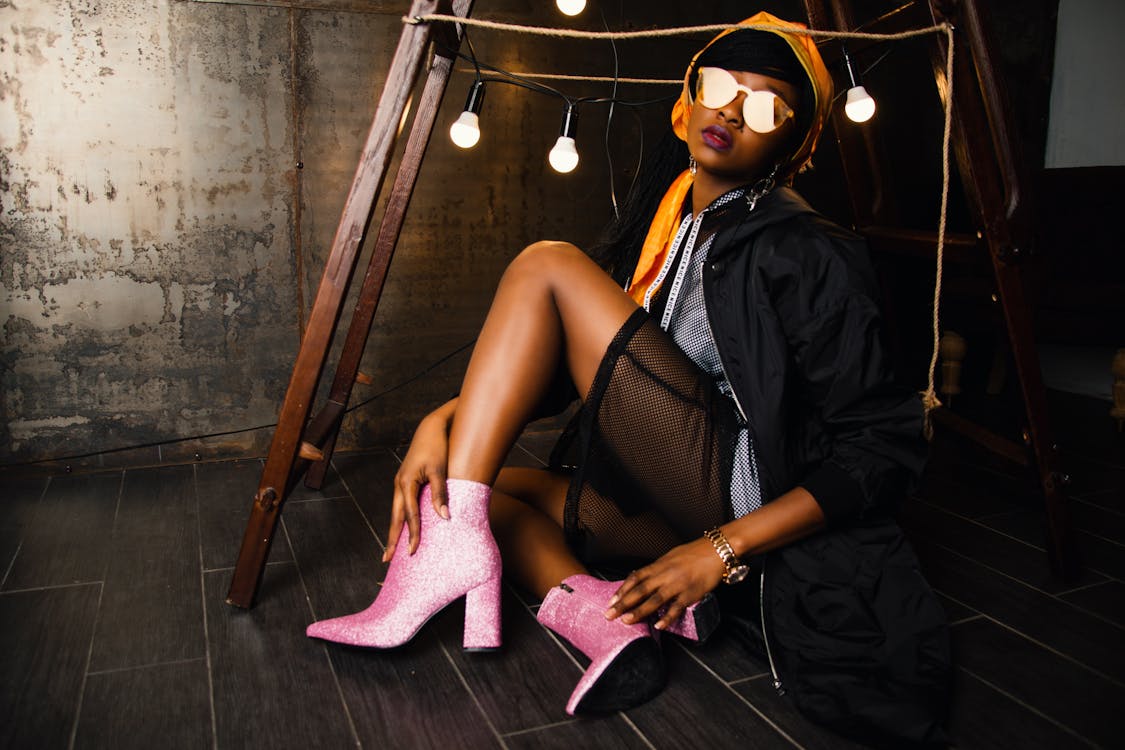 Free Woman Wearing Black Jacket Touching Her Boot Stock Photo