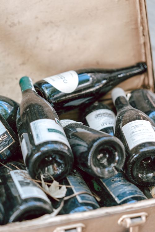 Free A collection of champagne bottles displayed in a vintage suitcase, perfect for wine enthusiasts. Stock Photo