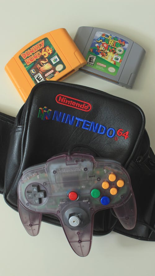 Free  Nintendo Game Boy Controller with Two Cartridges and Black Leather Case in Close Up View Stock Photo