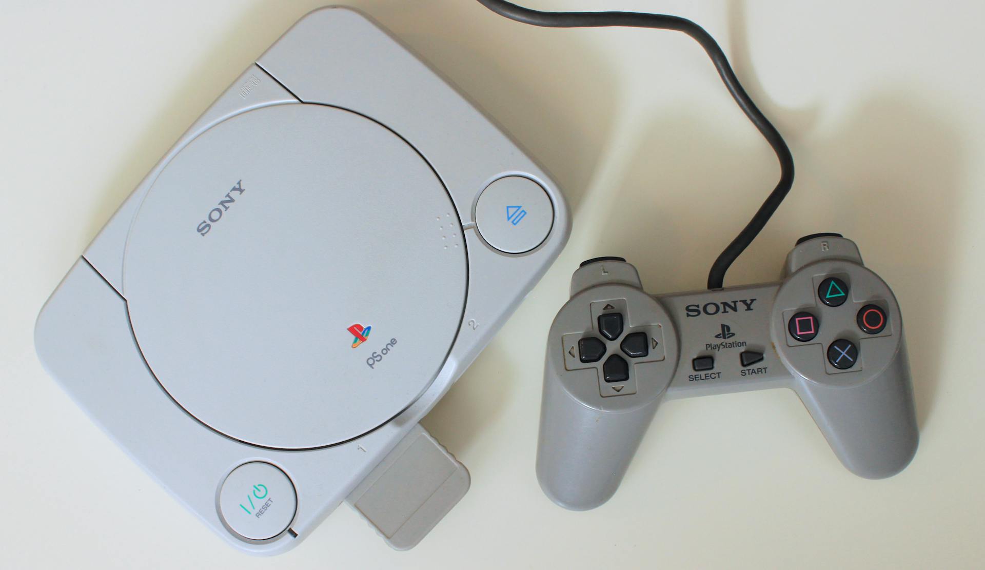 Close-up view of a retro Sony PlayStation One console with controller, ideal for game nostalgia enthusiasts.