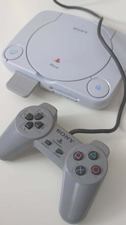 Close-Up Shot of a Game Console beside a Game Controller