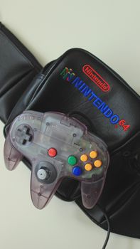 Close-up of a classic Nintendo 64 controller on a retro carrying case, evoking nostalgia.