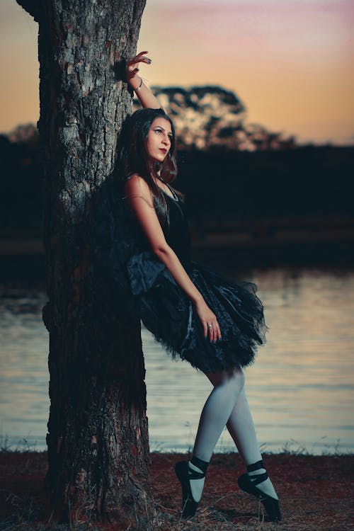 Woman in Black Dress Leaning on a Tree 