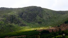 在多云的天空下，爱尔兰戈尔韦县的山脉郁郁葱葱，景色迷人