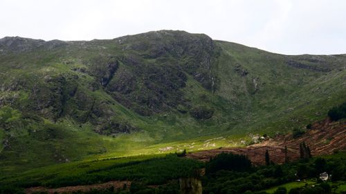 Free A captivating view of lush green mountains in County Galway, Ireland under a cloudy sky. Stock Photo