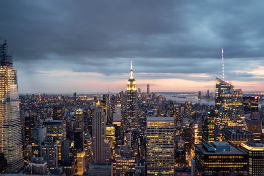 Breathtaking aerial view of New York City skyline at twilight, showcasing iconic skyscrapers under a dramatic sky.